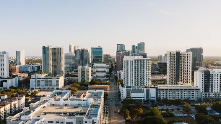Sunlit aerial view of Fort Lauderdale's downtown skyline with high-rises and palm trees
